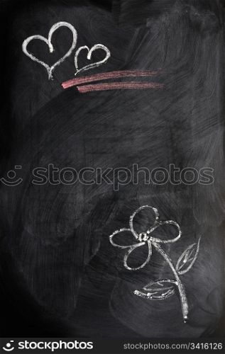 Hearts and flower drawn in chalk on a blackboard