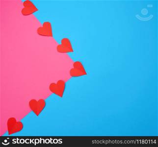 hearts cut out of red paper on a blue pink background, festive backdrop for Valentine&rsquo;s Day, flat lay, copy space