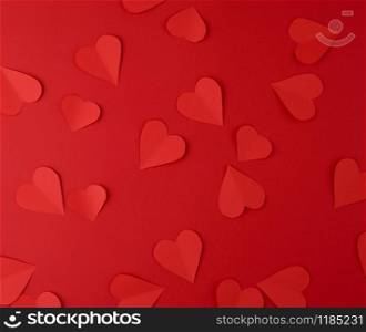 hearts cut out of red paper on a red background, festive backdrop for Valentine&rsquo;s Day, flat lay