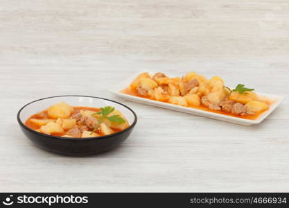 Hearty beef stew simmering on gray wooden background