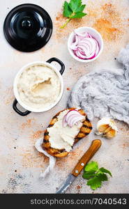 Hearty lard with garlic served with fresh bread on a rustic white table.