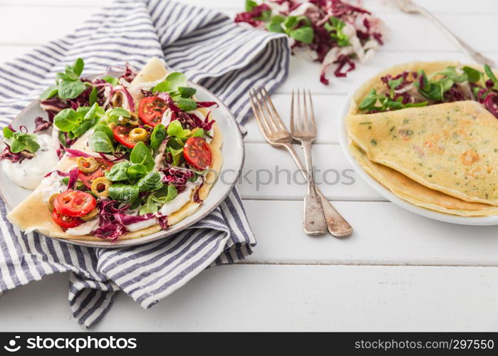 hearty pancakes with fresh salad, tomato and radicchio, top view