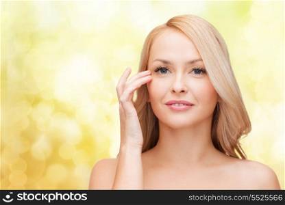 heath and beauty concept - face of beautiful woman touching her eye area