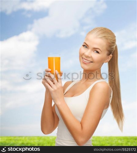 heath, diet and food concept - young woman holding glass of orange juice