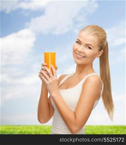 heath, diet and food concept - young woman holding glass of orange juice