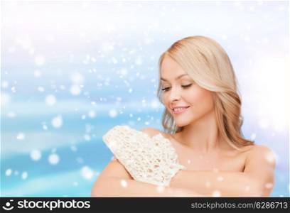 heath, people and beauty concept - beautiful young woman with bare shoulders washing herself over blue sky, snow and clouds background