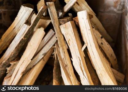 heating, warmth and coziness concept - close up of firewood in fireplace