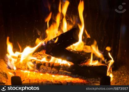 heating, warmth, fire and cosiness concept - close up of firewood burning in fireplace