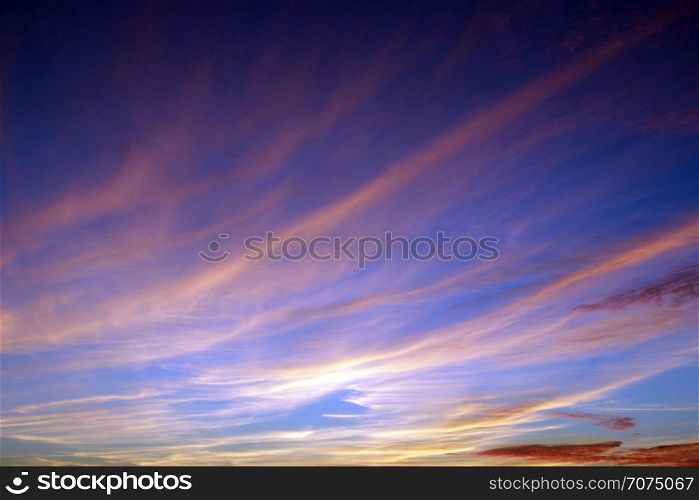 Heavenly landscape with pink clouds on purple sky during sunset. Beautiful evening sky with reddish clouds. Twilight with bright sunset. Sunny rays leaving with decline. Evening landscape. Heavenly landscape with pink clouds on purple sky during sunset.