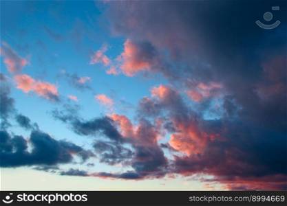 Heavenly landscape with pink clouds on purple sky during sunset. Beautiful evening sky with reddish clouds. Twilight with bright sunset. Sunny rays leaving with decline. Evening landscape. Heavenly landscape with pink clouds on purple sky during sunset.