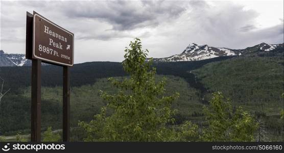 Heavens Peak signboard with mountain range in the background, Glacier National Park, Glacier County, Montana, USA