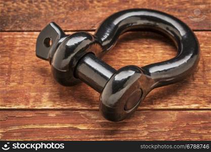 heavy duty shackle (d-ring) for vehicle recovery and towing on rustic red painted wood