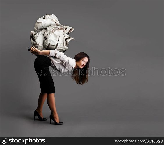Heavy idea concept. Woman is bending over under heavy crumpled paper