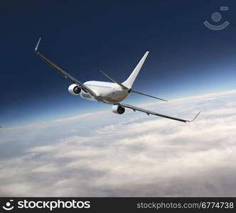 Heavy jumbo jet airplane flying above the clouds