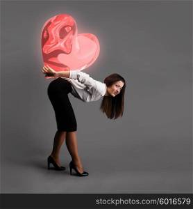 Heavy love concept. Woman is bending over under heavy heart symbol