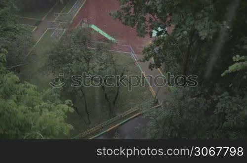 Heavy rain against the tree and a children&acute;s playground