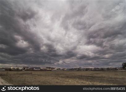 Heavy storm clouds above countryside landscape photo. Beautiful nature scenery photography with blurred background. Idyllic scene. High quality picture for wallpaper, travel blog, magazine, article. Heavy storm clouds above countryside landscape photo