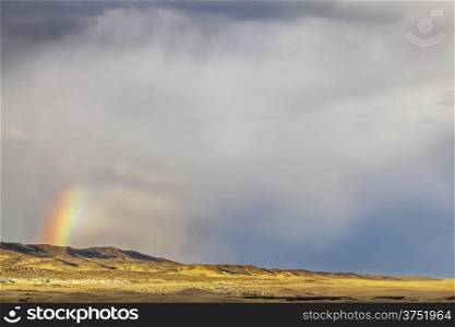 heavy storm clouds and rainbow over prairie in northern Colorado - Soapstone Prairie Natural Area