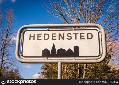 Hedensted city sign in Denmark with trees in the background