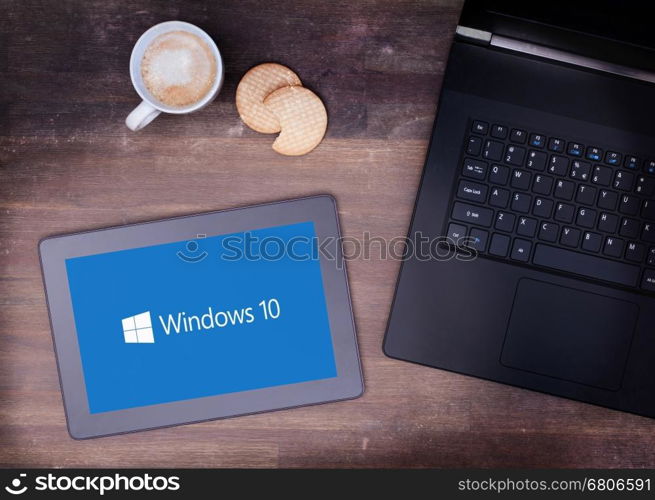 HEERENVEEN, NETHERLANDS, June 6, 2015: Tablet computer with Windows 10 background. Windows 10 is the new version of Windows OS by Microsoft Corporation; it starting July 29, 2015.