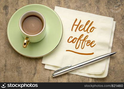 Hello coffee - cheerful handwriting on a napkin with a cup of coffee
