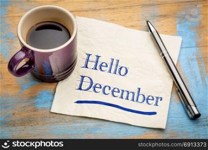 Hello December - handwriting on a napkin with a cup of espresso coffee