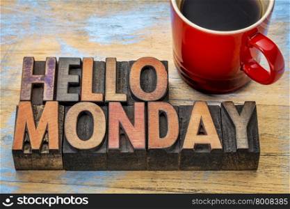 Hello Monday word abstract in vintage letterpress wood type printing blocks stained by color inks with a cup of coffee