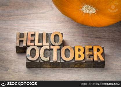 hello October greeting card - letterpress wood type blocks against grained wood with a pumpkin