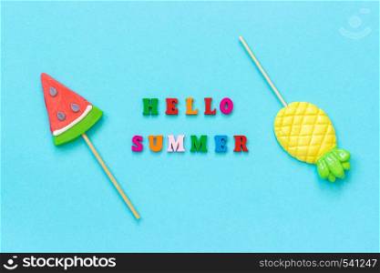 Hello summer colorful text, pineapple and watermelon lollipops on stick on blue paper background. Concept vacation or holidays Creative Top view Template Greeting card, postcard.. Hello summer colorful text, pineapple and watermelon lollipops on stick on blue paper background. Concept vacation or holidays Creative Top view Template Greeting card, postcard