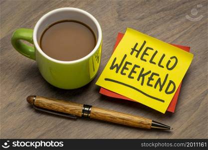 hello weekend - handwriting on a sticky note with a cup of coffee, cheerful message
