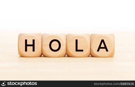 Hello word in spanish language in wooden blocks on table. White background. Copy space