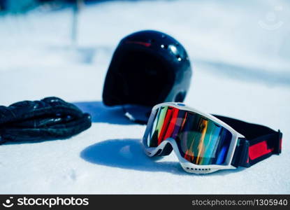 Helmet, glasses and gloves on the snow closeup, nobody. Winter extreme sport concept. Mountain skiing equipment