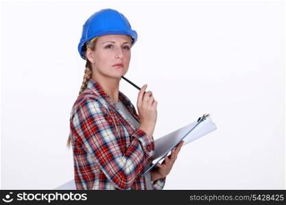 helmeted craftswoman with clipboard looking inspired