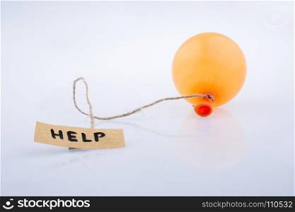 Help word written paper attached to a balloon with a string
