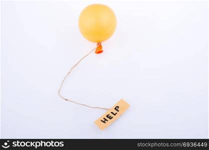 Help word written paper attached to a balloon with a string