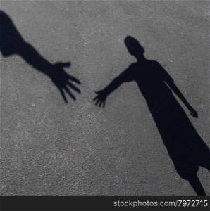 Helping Hand with a shadow on pavement of an adult hand offering help or therapy to a child in need as an education concept of charity towards needy kids and teacher guidance to students who need tutoring.