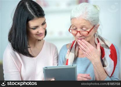Helping old woman use a tablet computer