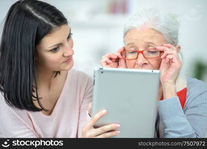 Helping old woman use a tablet computer