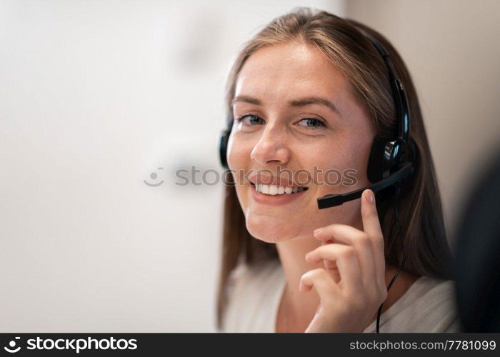 Helpline female operator with headphones in a call center.Business woman with headsets working in a call center. Selective focus. High-quality photo. Helpline female operator with headphones in call centre.Business woman with headsets working in a call center. Selective focus 