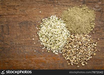 hemp seed, hearts and protein powder - small piles on a grunge wood - top view
