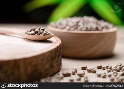 Hemp seeds on round wooden bowl with hemp leaf. Legalized cannabis concept for medical and healthcare purpose.. Legalized cannabis concept for medical and healthcare purpose shown by hemp seed