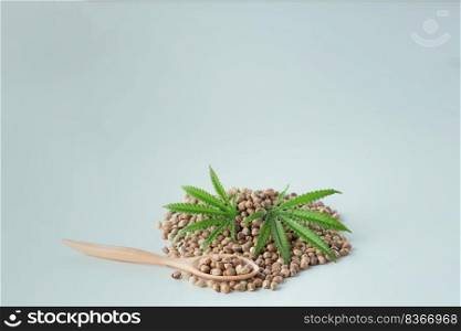 Hemp seeds with green sativa hemp leaf on top of it. Legalized marijuana concept. Empty background for copyspace.. Hemp seeds with green sativa hemp leaf on top. Legalized marijuana concept.