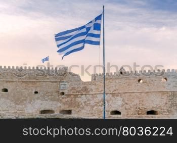 Heraklion. The old Venetian fortress.. A view of the Venetian Fortress and the Greek flag over her on the sunset. Crete.