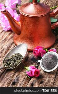 herb rose buds tea. Stylish copper kettle, tea rose buds and dry tea leaf