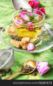 herb tea with tea rose petals. rosebuds and a glass of herbal tea