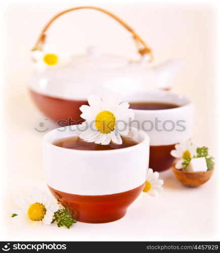 Herbal chamomile cup of tea with daisy flower, shallow depth of field, healthy drink, relaxing anti stress spa beverage, teatime