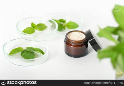 herbal cosmetic cream and mint leaves in petri dish, natural cosmetics, laboratory developed face care, selective focus.. herbal cosmetic cream and mint leaves in petri dish, natural cosmetics, laboratory developed face care, selective focus