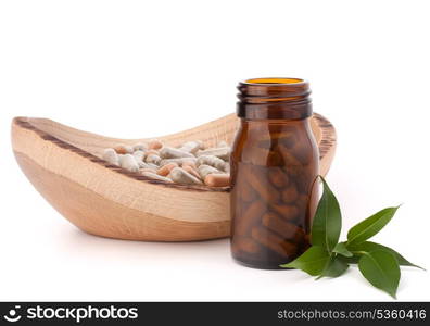 Herbal drug capsules in brown glass bottle isolated on white background cutout. Alternative medicine concept.