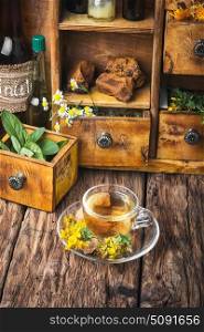 Herbal Hypericum tea.. Hypericum.Glass cup with herbal tea from inflorescences Hypericum on a wooden background