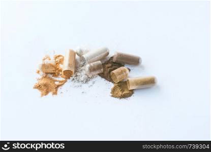 Herbal pills. Open capsules and powder on white background. Medicines. Herbal pills. Open capsules and powder on white background